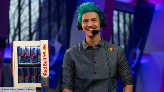 Ninja with a headset sat in front of a Red Bull fridge