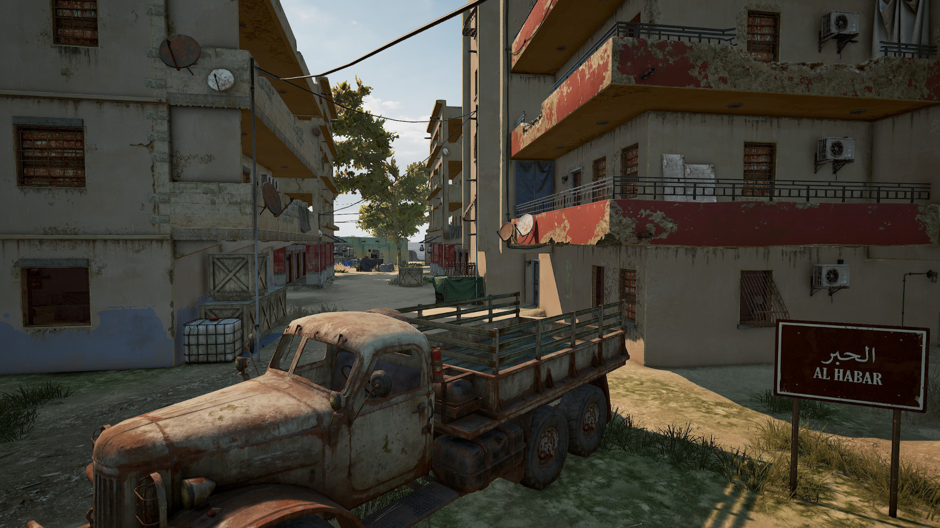 Best PUBG Karakin drops: Al Habar, with a rusty truck next to two tall apartment buildings.