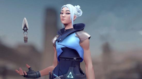 Valorant character Jett stands in front of a blurred background, nonchalantly juggling a kunai in her hand