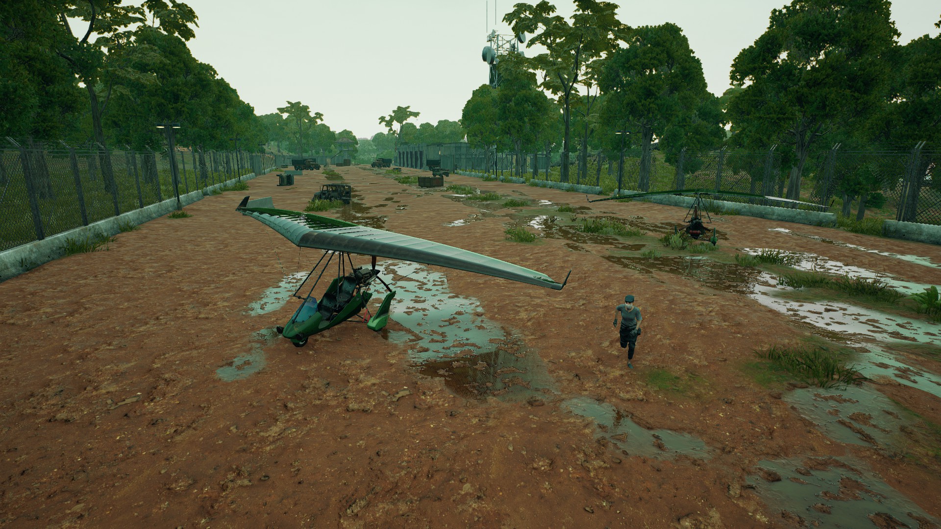 PUBG Sanhok drops: A player running through Sanhok's Airfield, with several glider planes and trucks parked on the airstrip.