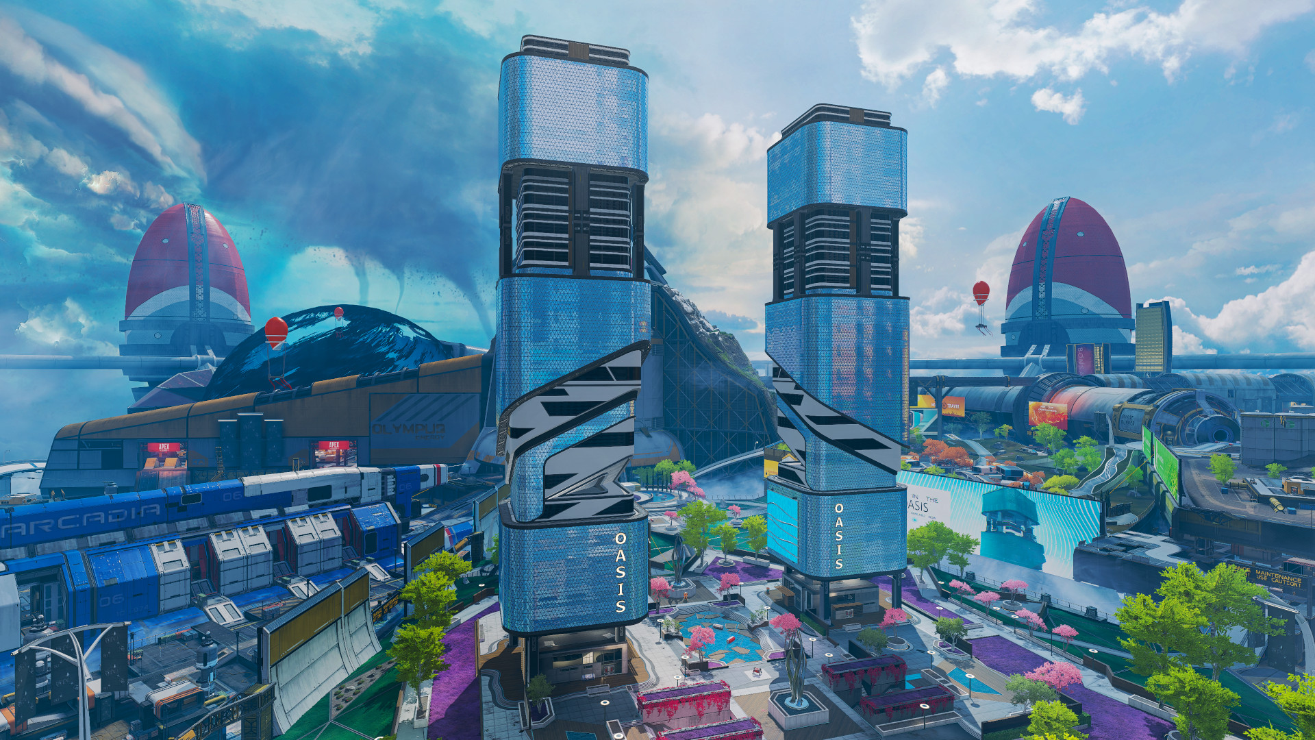 Apex Legends Season 7: A wide-angle view of the Olympus map, showing two large buildings in the Oasis area, with various other buildings and scenery in the background.