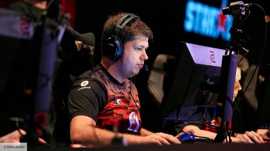 CSGO pro Karrigan sitting at a gaming PC wearing a mousesports jersey