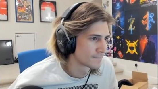 Twitch streamer xQc wearing a white jumper and black headphones