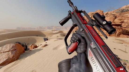 A red and black AUG rifle in front of a desert scene