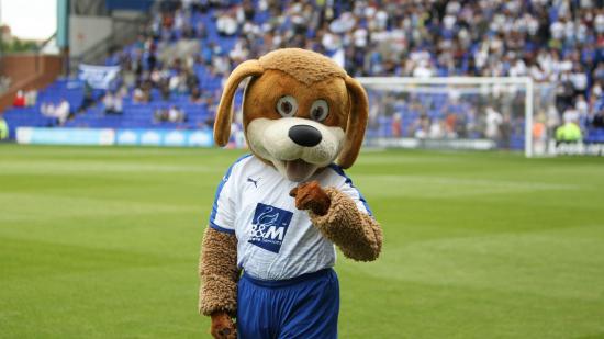 Tranmere Rovers' mascot, a dog called Rover, fistpumps on the pitch