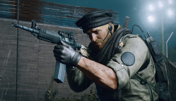 A bearded man points a rifle as he stealthily approaches a building