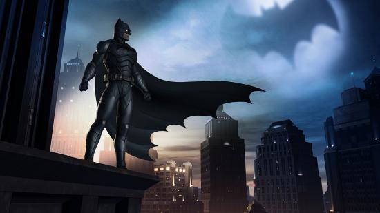 Batman looks over the streets of Gotham, his cloak billowing and bat-signal in the sky