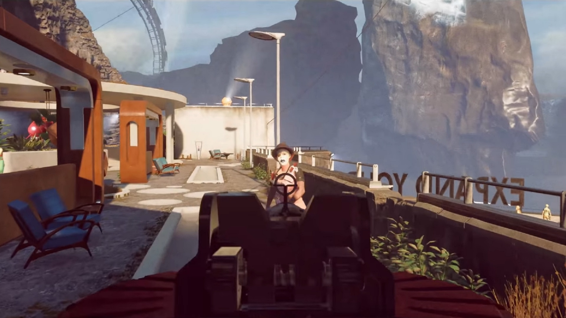 Deathloop release date: The player pointing a gun at a masked opponent, fighting in a 60s café on the edge of a cliff.