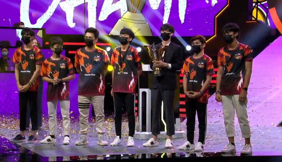 A team collects their trophy on stage at a Free Fire tournament