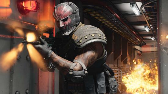 A Warzone operator in a red mask runs down a flaming corridor, firing his weapon