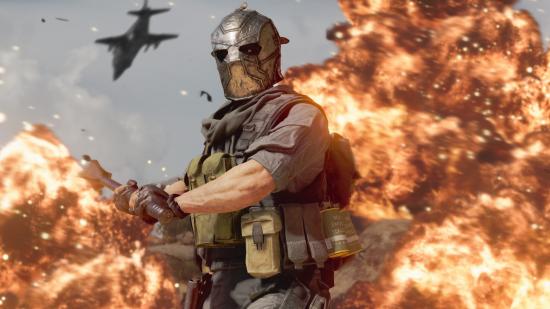A Black Ops Cold War operator, wearing a silver full-face helmet and holding a large mace, stands in front of a massive explosion
