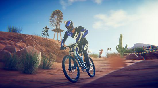 A man in blue lycra and a blue helmet races a BMX bike along a dust track