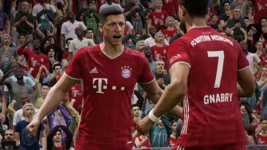 Robert Lewandowski, wearing a red Bayern Munich kit, celebrates a goal with another player in front of a crowd