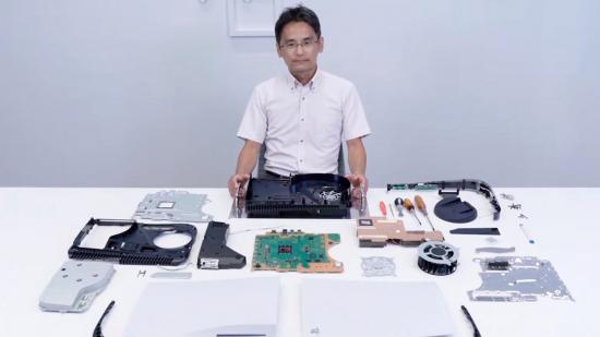A Sony engineer sits at a desk with a PS5 taken apart in front of him