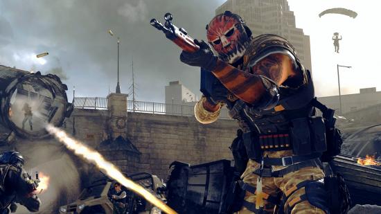 Best Warzone loadouts: A Warzone operator in a red mask aims a C58 assault rifle while a battle ensues behind him. One player is firing a rocket launcher, and another is parachuting through the air
