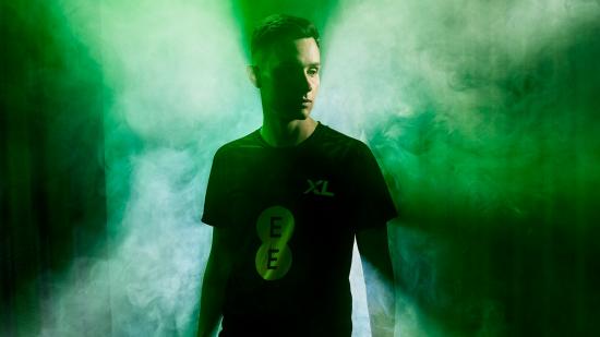 FIFA pro Tom Leese wearing a black Excel Esports jersey, surrounded by smoke and green lighting