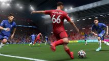 A Liverpool player in a red kit looks to cross the ball while being closed down by two Chelsea players in blue