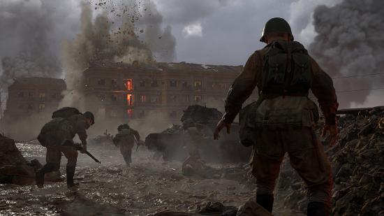 A soldier stands overlooking a battlefield as soldiers run in front of him in all directions.