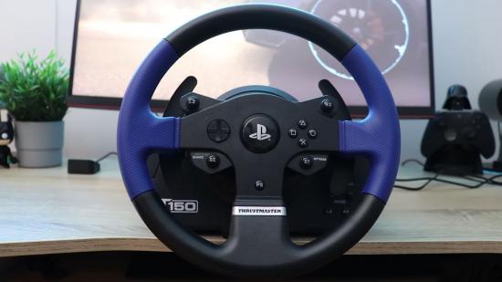 A blue an black racing wheel controller mounted on a wooden desk