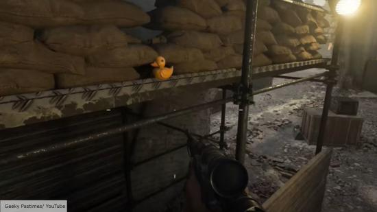 Vanguard easter egg: A first person view of a Vangaurd lpayer finding a yellow rubber duck sat in front of some sand bags