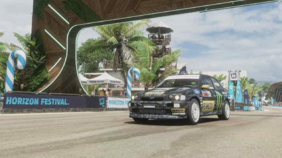 Forza Horizon 5 Tis The Season To Be Hooning: The Hoonigan Gymkhana 10 Ford Escort Cosworth Group A 1991 can be seen in front of a stadium.