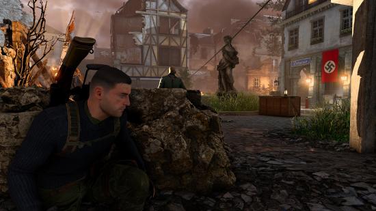 Sniper Elite 5 review: A sniper peers around a wall of sandbags as he takes cover