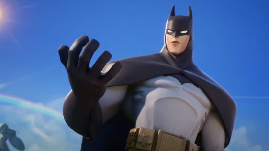 MultiVersus Need PS Plus Xbox Live: Batman can be seen looking at something in his hand.