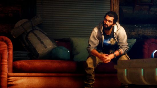 Assassin's Creed Basim game need: Basim sitting in a sofa in a hoodie