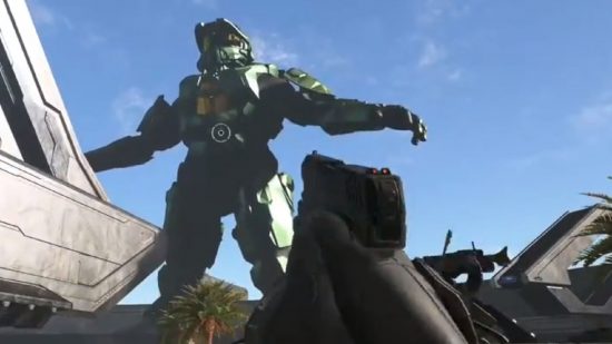 Halo Infinite Forge Change The Game: A Spartan can be seen holding a pistol and looking at a giant masterchief