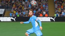 FIFA 23 best midfielders: Kevin de Bruyne looks up at a football flying just above his head