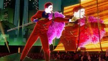 Just Dance 2023 Crossplay: A coach can be seen on a stage podium