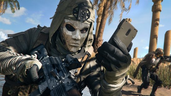 Warzone 2 easter eggs DMZ - An operator in a full face helmet holds a gun in one hand and a mobile phone in the other