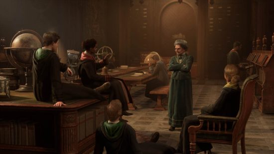 Hogwarts Legacy on Game Pass: A group of students talking to a tutor in a grand hall in Hogwarts.