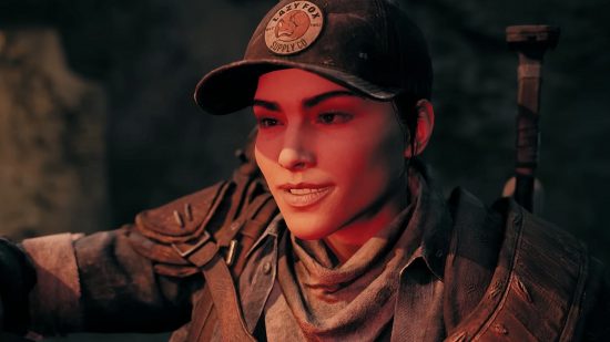 Remnant 2 preview: A close up of a woman wearing a baseball cap, bathed in red light