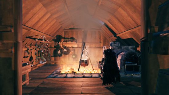 Valheim Building Guide: A person can be seen by a campfire