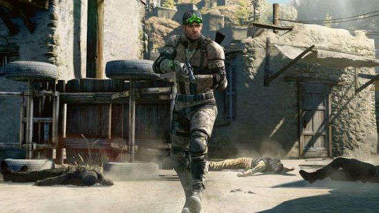 Splinter Cell battle royale: Sam Fisher walks through a village with bodies on the ground around him. He is wearing camouflaged military gear and night vision goggles
