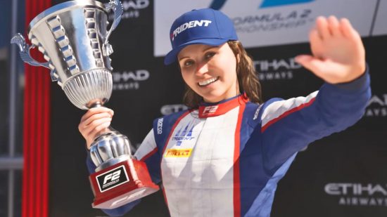 F1 23 Game Pass: a female racing driver in a white and blue race suit smiles and waves while holding a large silver trophy