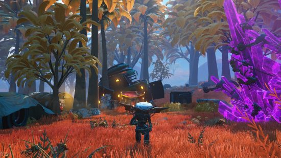 Best space games: A screenshot showing a multi-colored forest in No Man's Sky with a person in a dark spacesuit surrounded by trees.