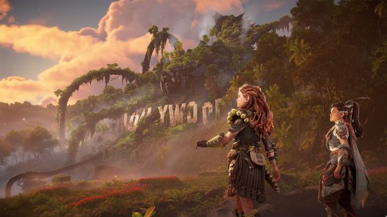 Best RPG games: Horizon Forbidden West's Aloy and another character standing overlooking an overgrown Hollywood sign, covered with leaves and massive robotic limbs.
