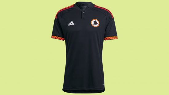 FC 24 best kits: A black football shirt with a white badge featuring a wolf's head and orange accents on the sleeve