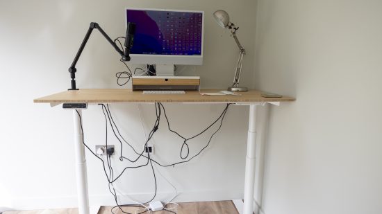 The FlexiSpot E8 standing desk with an imac and mic boom on top