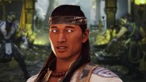 Mortal Kombat 1 review: Liu Kang with glowing white eyes, imposed on top of a blurred backdrop of a fight stage