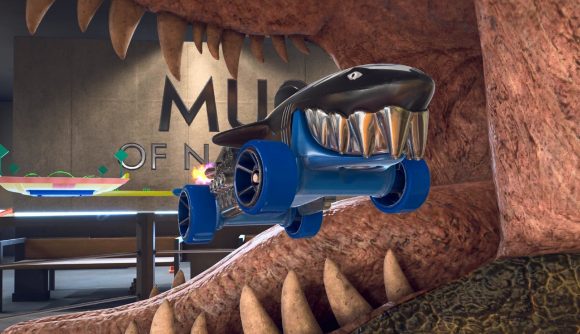 Hot Wheels Unleashed 2 review: A blue and black car that looks like a shark boosts through the open jaws of a dinosaur