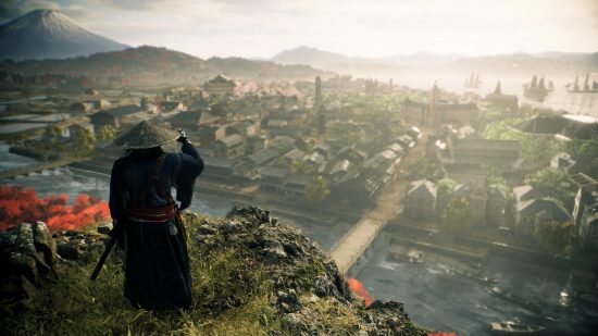PS5 exclusives: A samurai wearing a large hat overlooking a village by a river in Rise of the Ronin.