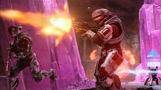 Best games: A Spartan running while another one fires to the left, surrounded by purple crystals, in Halo Infinite.