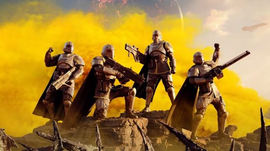 Best crossplay games: A team of Helldivers soldiers wearing dark grey armor and capes, stand on a rock with yellow smoke behind them
