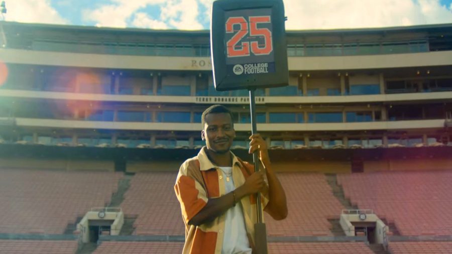 College Football 25: A man in an orange shirt holds up a sign with a large red number 25 written on it. Behind him is a football stadium