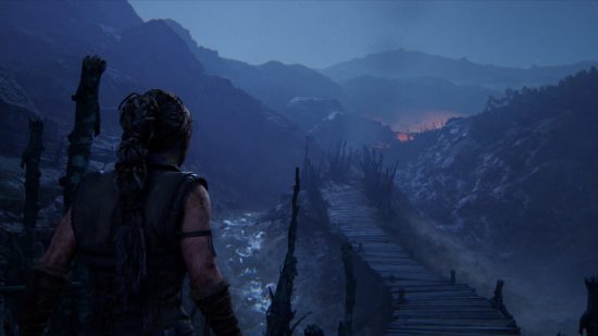 New Xbox games: A screenshot of Hellblade 2 showing Senua looking over a muddy, hilled area at night.