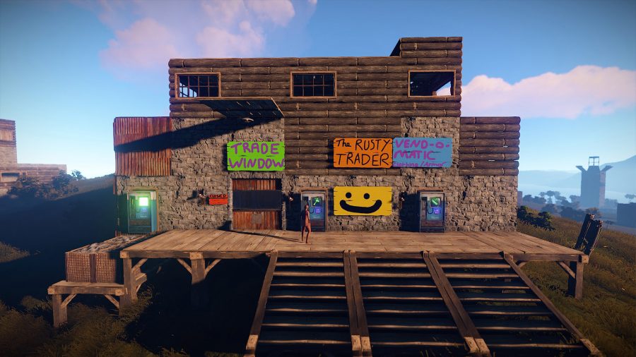 A trading post in Rust: a square building decorated with colourful signs and multiple staircases leading up to it