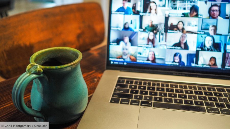A mug sits next to an open laptop, with a video call open